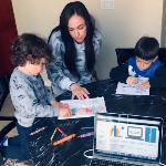 Adult with two children looking at water education materials