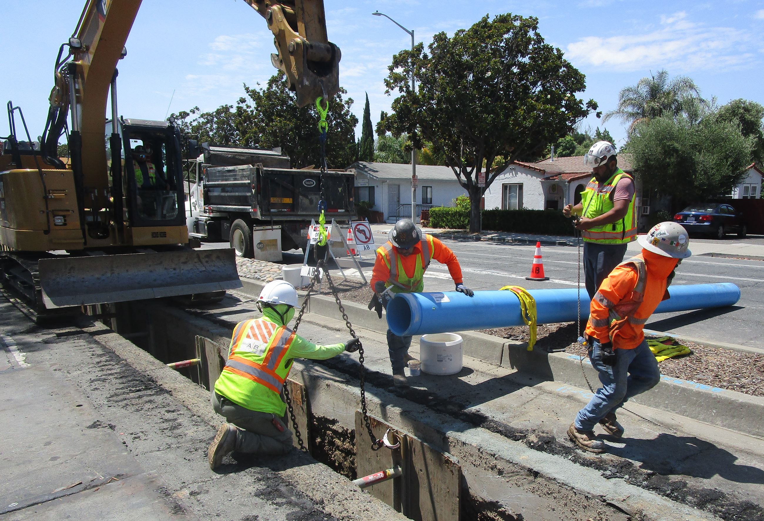 Picture of construction people and a blue pipe